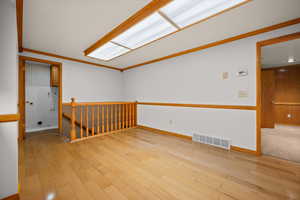 Unfurnished room featuring light wood finished floors and ornamental molding