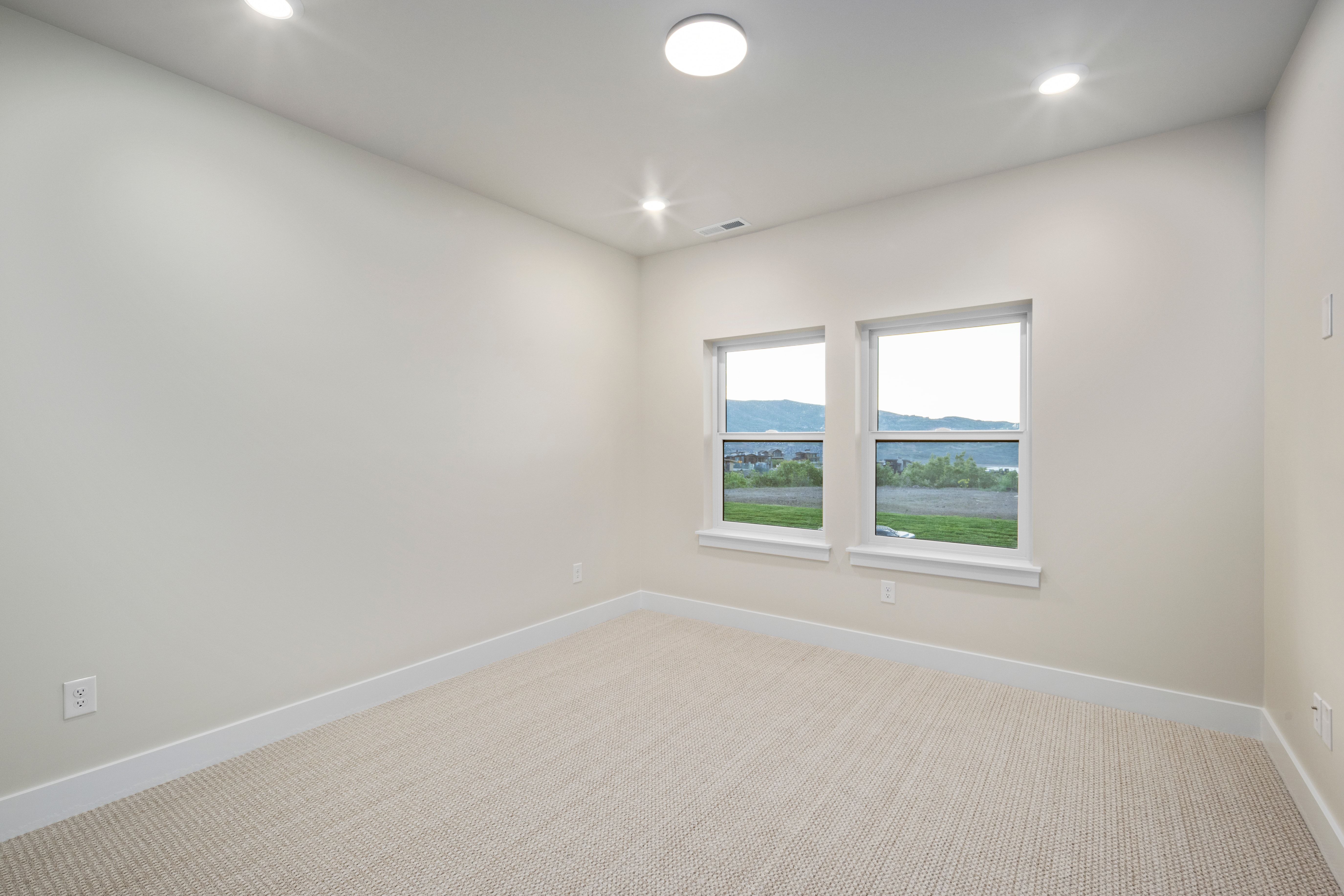 Room featuring two windows, neutral carpet, recessed lighting, and white baseboards