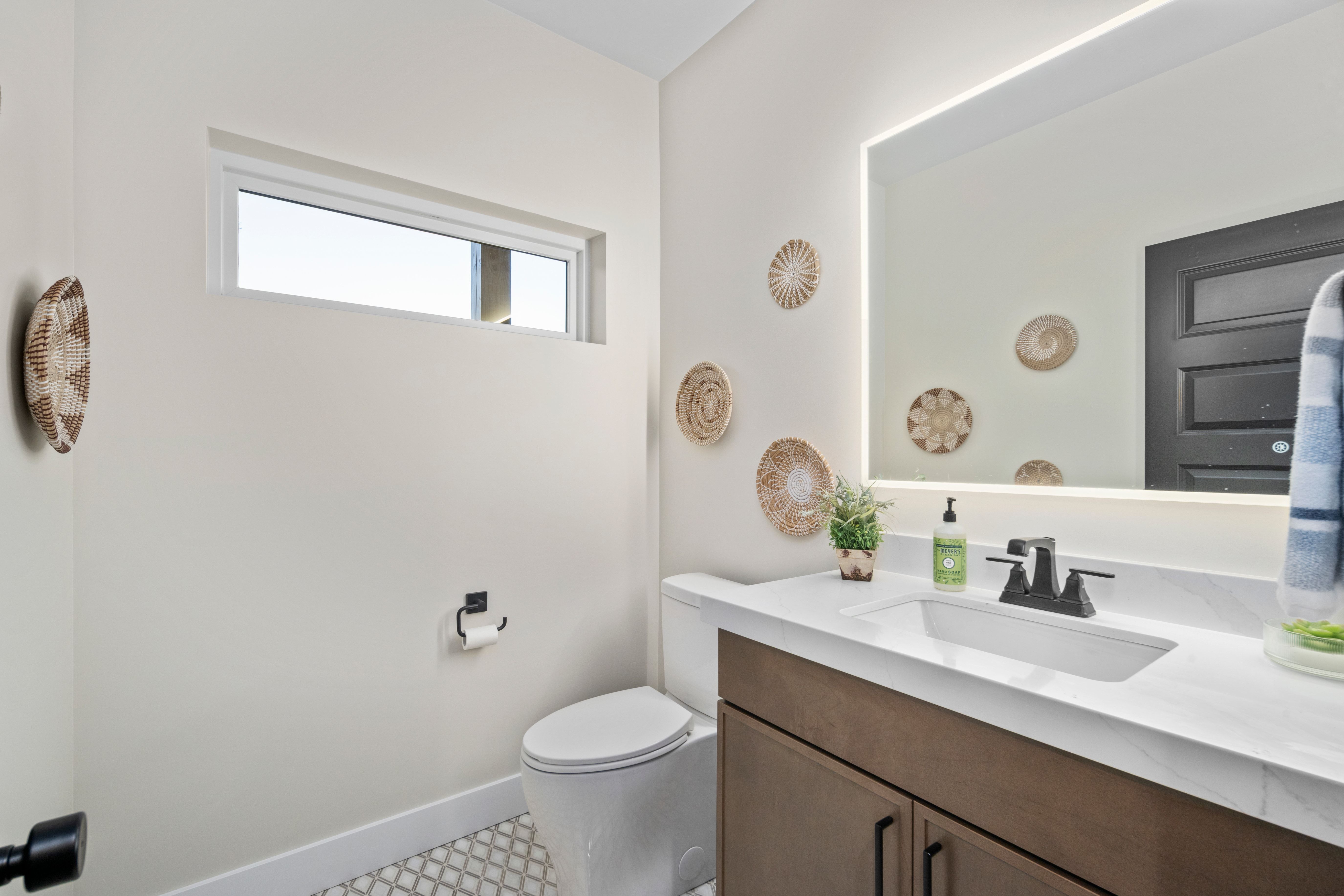 Contemporary bathroom vanity featuring a solid surface countertop, integrated sink, and matte black faucet