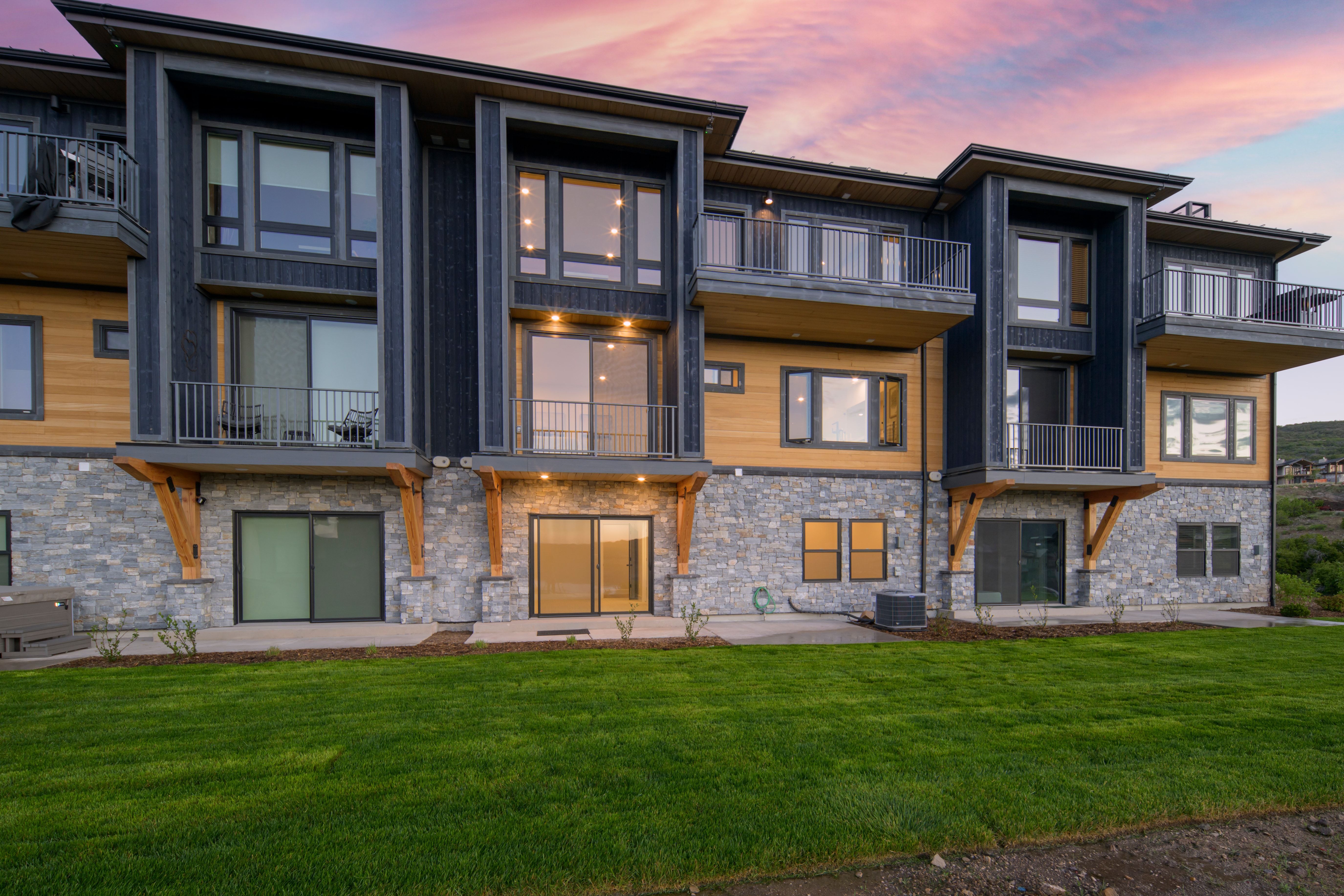 Contemporary multi-level building with stone veneer and dark siding