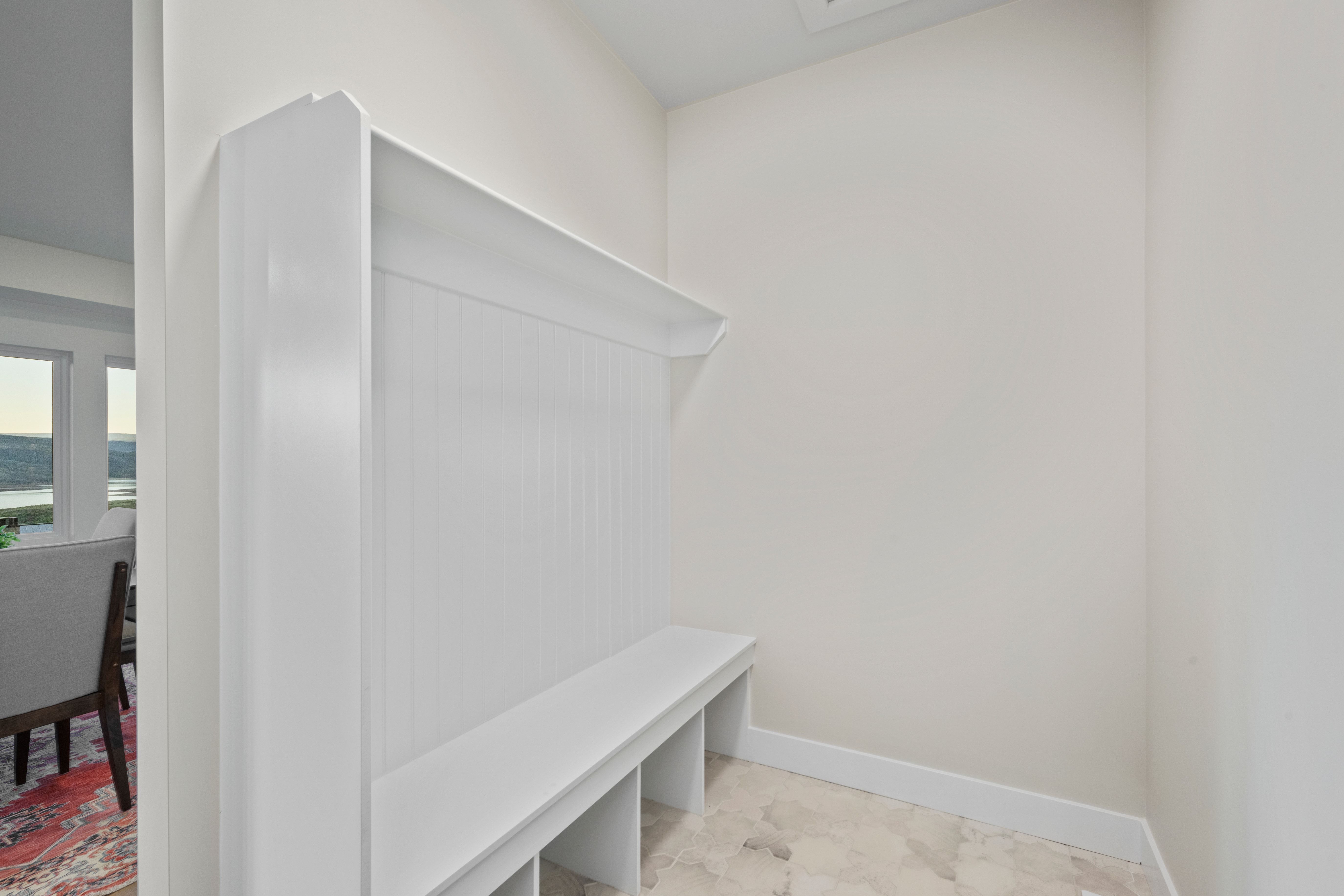 Built-in mudroom bench with beadboard backing, overhead shelf, and individual storage cubbies