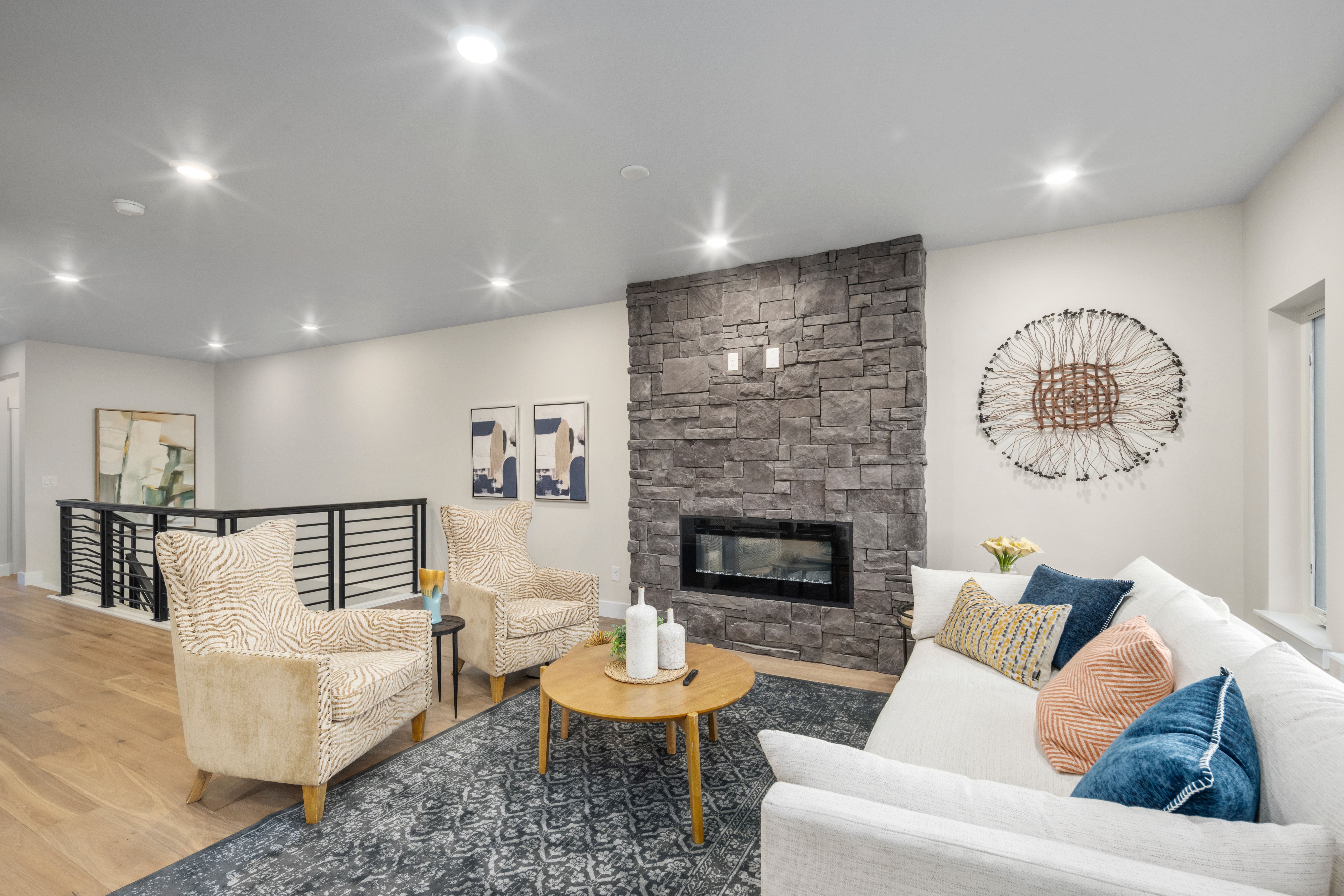 Living area featuring a stone accent wall with a built-in linear fireplace, recessed lighting, and wood-finish flooring