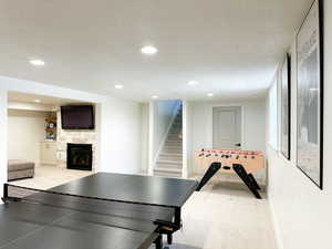 Rec room featuring a stone fireplace, and recessed lighting