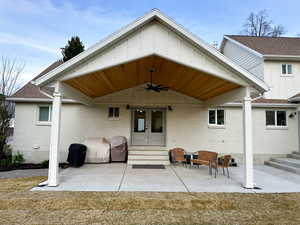 Back of property featuring entry steps, a patio, ceiling fan, and a lawn