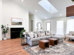 Living room with lofted ceiling, wood floors, and a lot of natural light
