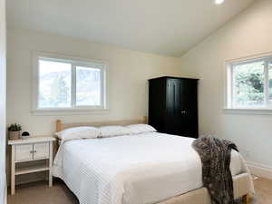 Carpeted bedroom with lofted ceiling