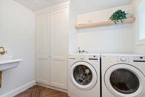 Laundry room with parquet floors and separate washer and dryer