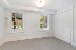 Unfurnished bedroom with light carpet and a closet