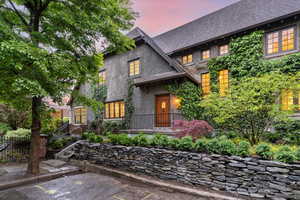 View of front of house featuring stucco siding and roof with shingles