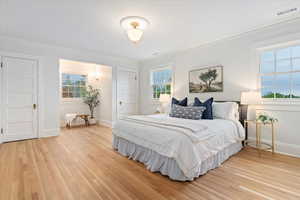 Bedroom featuring light wood-style floors and ornamental molding
