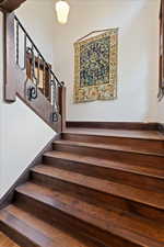 Staircase with baseboards and wood finished floors