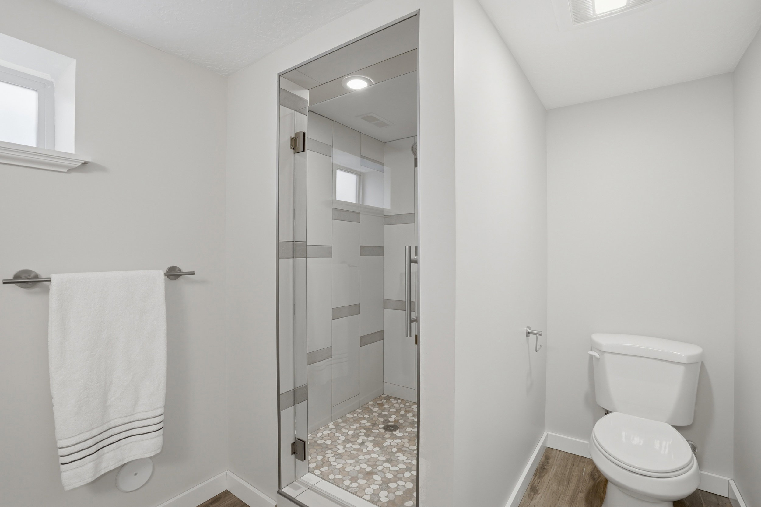 Full bathroom with a shower stall and light wood-style floors