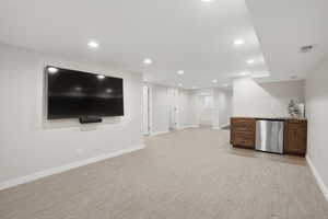 Bar featuring recessed lighting, light stone countertops, light colored carpet, stainless steel appliances, and dark wood finish cabinetry