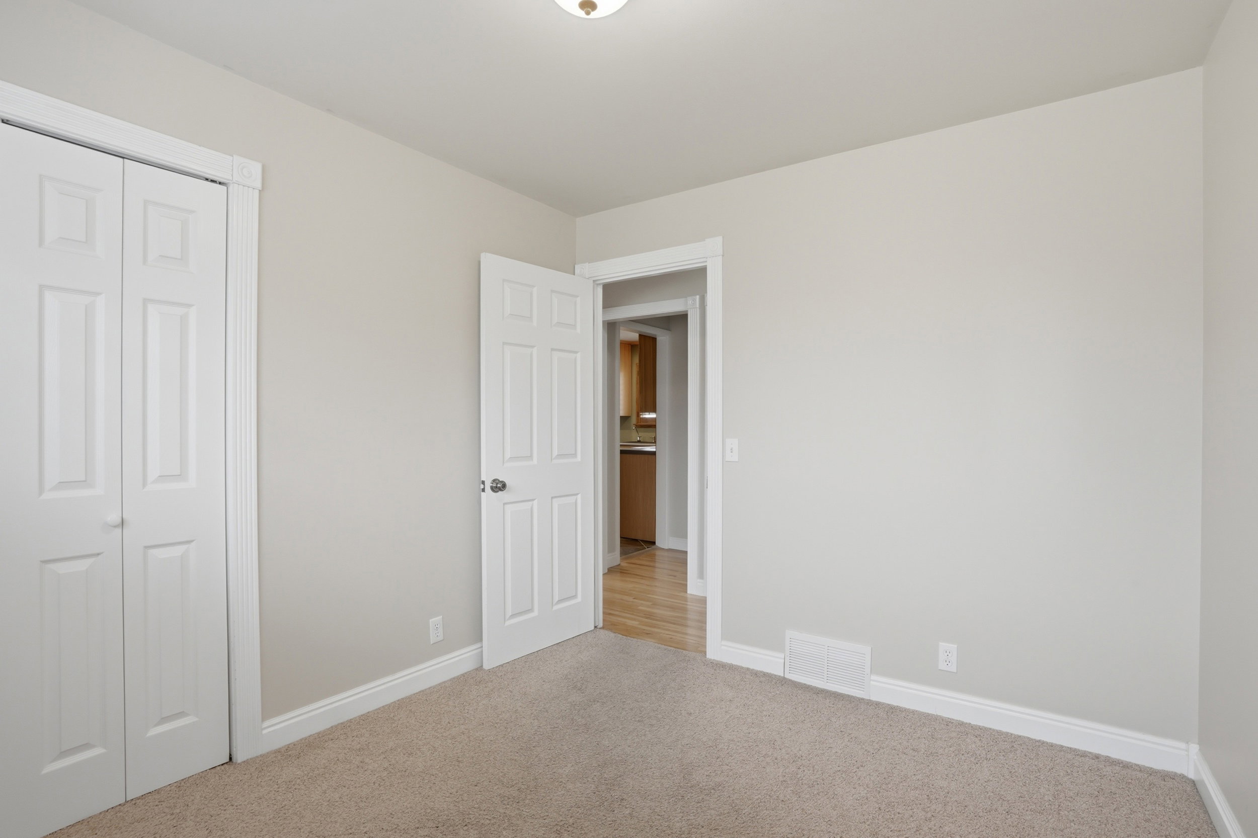 Unfurnished bedroom with light colored carpet and a closet