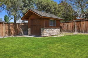 Detached shed with stone veneer base and wood siding