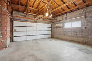 Garage featuring concrete block wall and a garage door opener