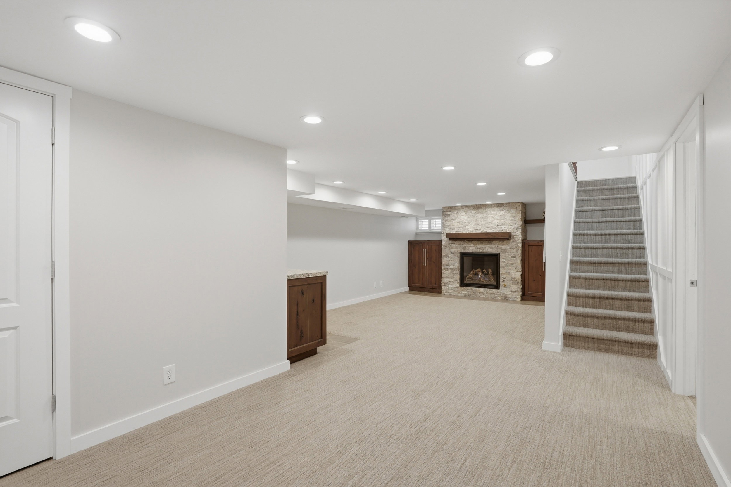 Finished below grade area featuring recessed lighting, a fireplace, and light colored carpet