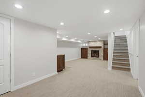 Finished below grade area featuring recessed lighting, a fireplace, and light colored carpet
