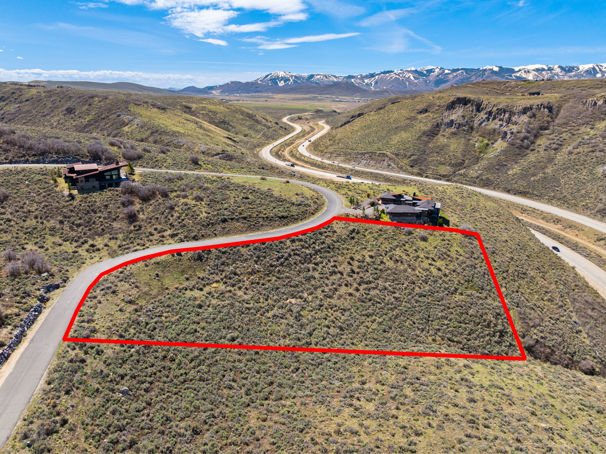 Aerial overview of property's location featuring property boundaries highlighted and a mountain backdrop