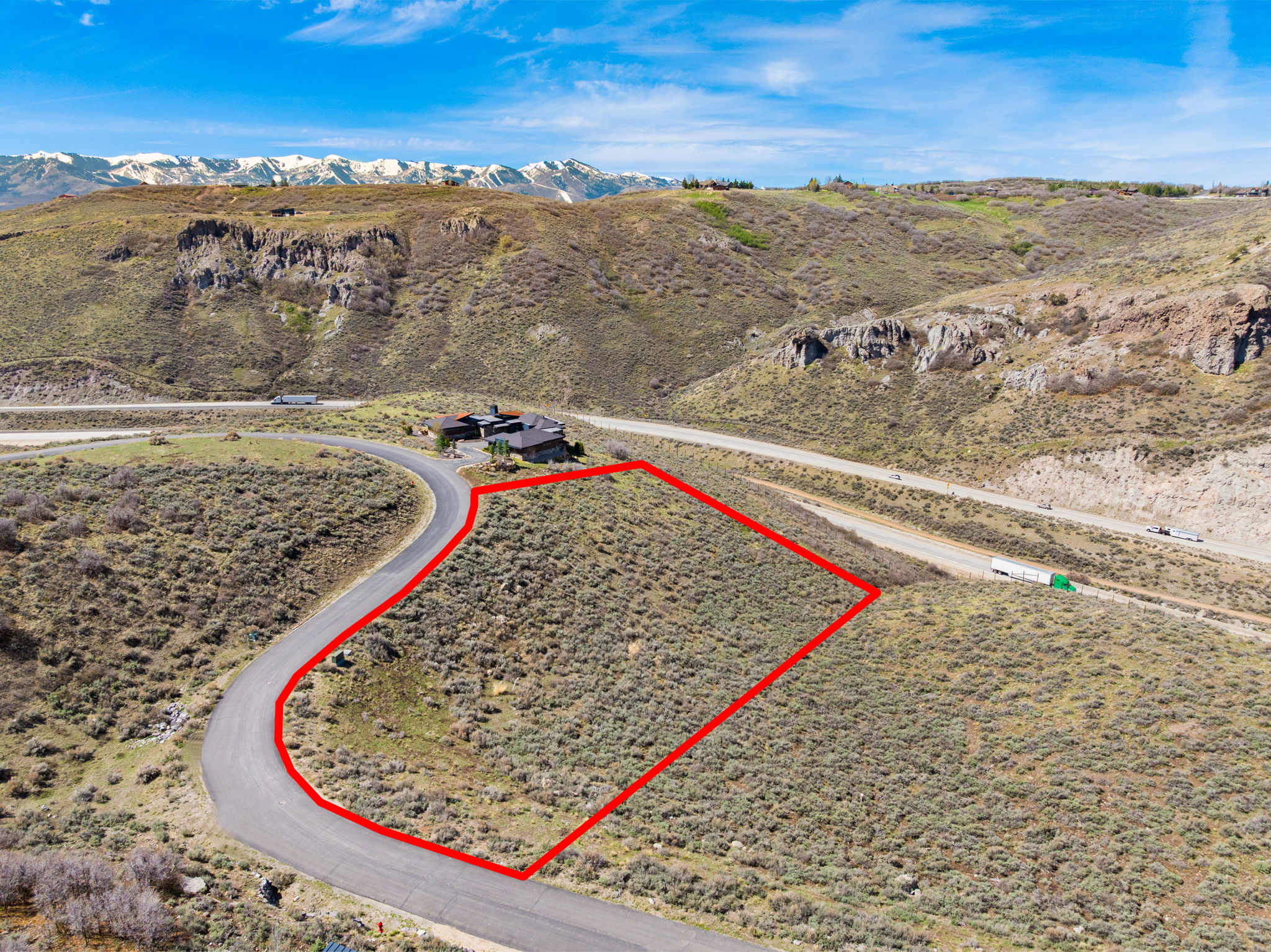 Aerial view of property's location with a mountain backdrop and property parcel outlined