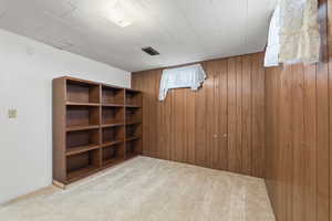Bedroom in basement featuring carpet floors and wooden walls