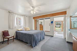 Primary bedroom with carpeted bedroom with baseboards and a ceiling fan. Door to solarium.