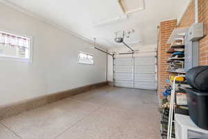 Garage with baseboards and a garage door opener
