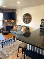 Living room with light wood-style floors, a fireplace, a textured ceiling, and recessed lighting