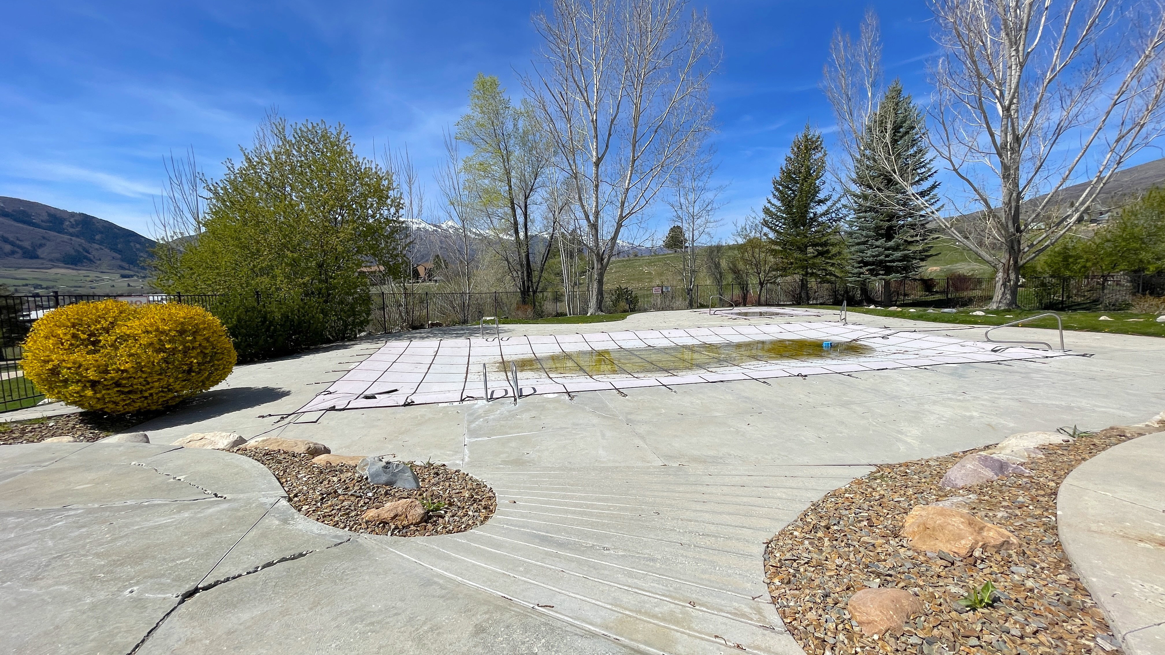View of tenced swimming pool and mountains