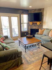 Living area featuring light wood-type flooring, a fireplace, and recessed lighting