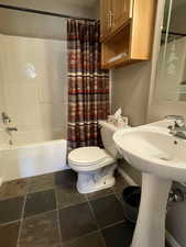 Full bath featuring toilet and shower / bath combination with curtain
