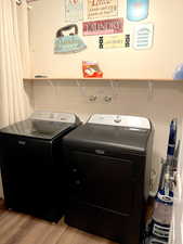 Laundry room with light wood-style flooring and washer and clothes dryer