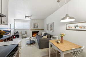 Living area with a warm lit fireplace and a textured ceiling