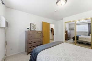 Bedroom featuring light colored carpet and a closet