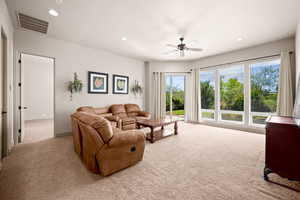 Living area with recessed lighting, light colored carpet, and ceiling fan