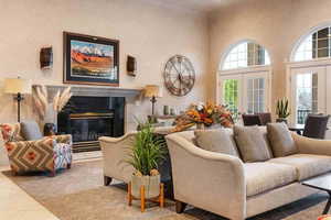 Living area featuring a premium fireplace, a high ceiling, and french doors