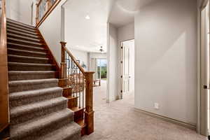 Staircase with carpet flooring, a ceiling fan, and recessed lighting