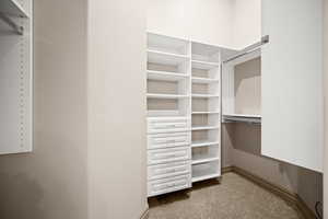 Walk in closet featuring dark colored carpet