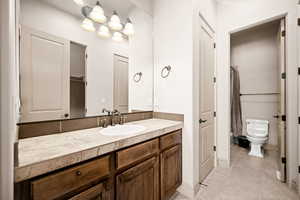 Full bathroom with a closet, vanity, a shower with shower curtain, and light tile patterned floors