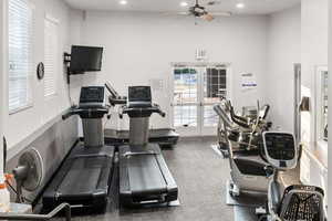 Workout area featuring french doors, ceiling fan, and a high ceiling