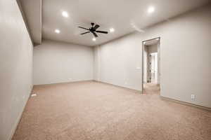 Empty room with a ceiling fan, recessed lighting, and light carpet