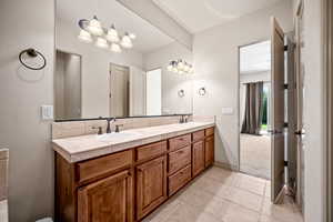 Full bath featuring double vanity and light tile patterned floors