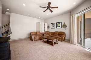 Carpeted living room featuring ceiling fan and recessed lighting