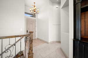 Hallway featuring suspended lighting, light colored carpet, and light tile patterned floors