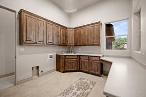Laundry area with cabinet space, hookup for a washing machine, light tile patterned floors, and hookup for an electric dryer