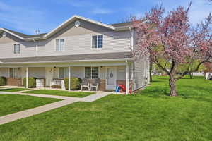 Traditional-style house featuring a porch, brick siding, and a front lawn