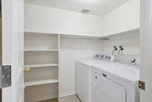 Laundry area with independent washer and dryer and baseboards