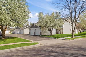 View of front of home with a front yard, a residential view, roof with shingles, and brick siding