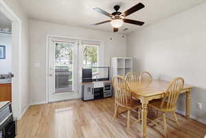 Dining room with light wood-style floors and a ceiling fan