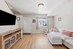 Living area with light wood finished floors and baseboards